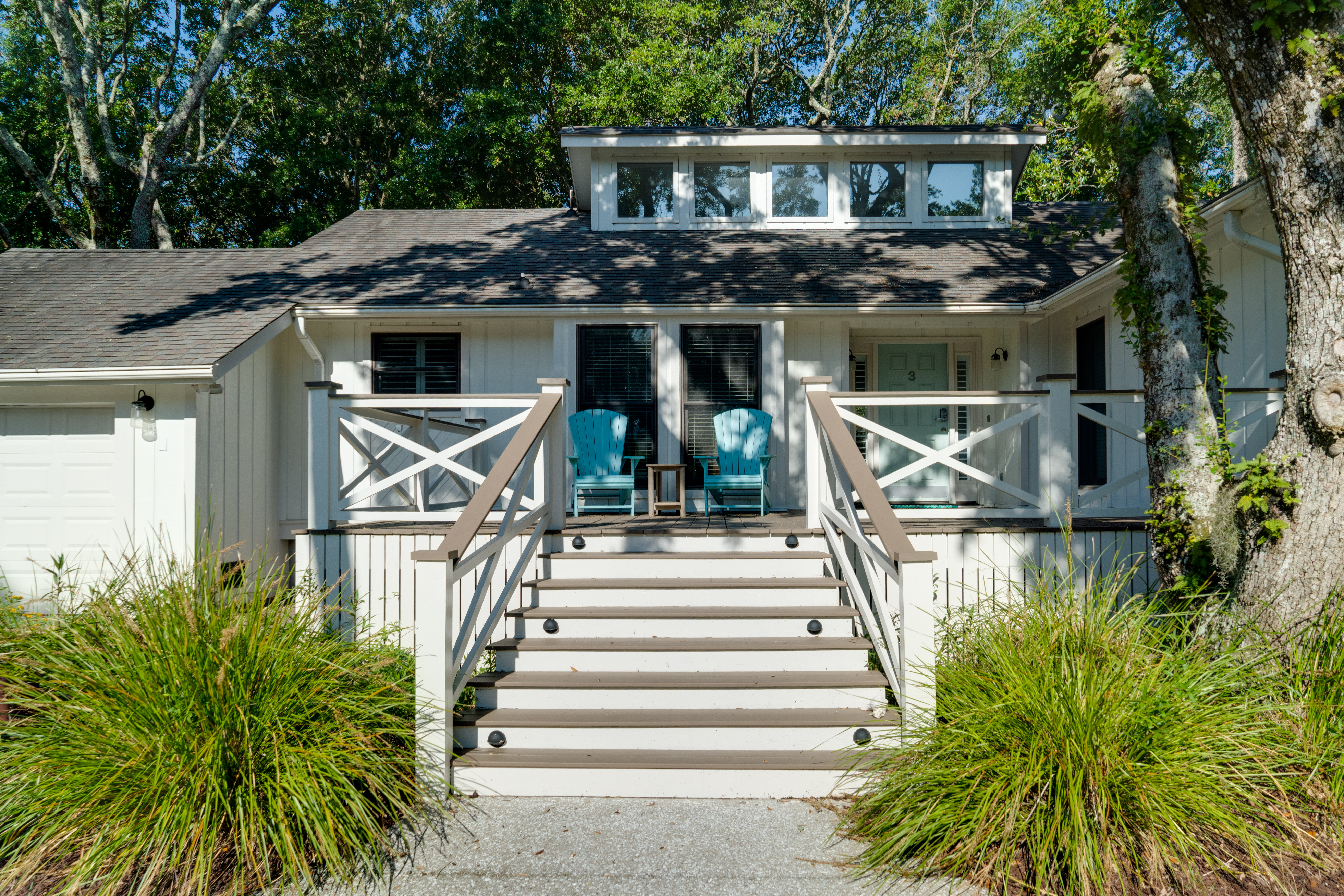 White coastal cottage with blue chairs